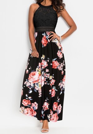 Robe maxi noire à fleurs avec un corsage en dentelle, un col halter et une jupe fluide ornée de grandes roses roses et rouges sur un fond noir.