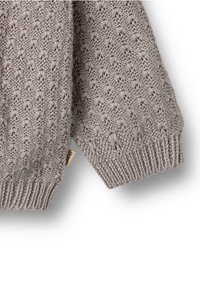 Graues gestricktes Kleidungsstück mit einem strukturierten Muster und kleinen Sternformen. Rippbündchen und Saum verleihen Details. Enthält ein Etikett an der Seite.