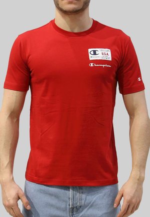 Rode T-shirt met korte mouwen van katoen met een ronde hals. Heeft een 'Champion' logo op de borst en een klein logo op de mouw.