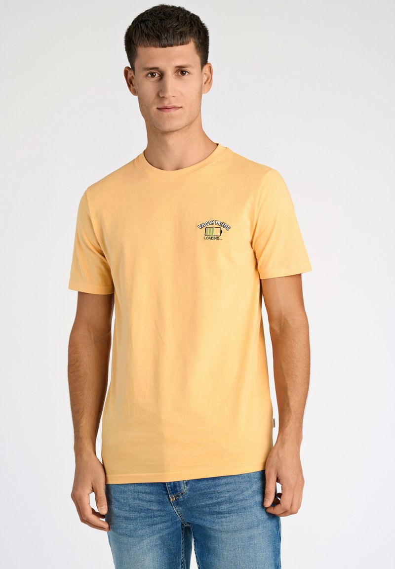 Camiseta de algodón amarilla con mangas cortas, escote redondo, que presenta un pequeño gráfico que dice "CARGANDO MODO VACACIONES..." en el pecho.