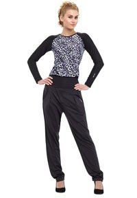 Athletic outfit featuring a black and white leopard print long-sleeve top with black sleeves, paired with black loose-fitting pants.