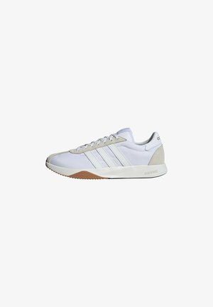 Witte Adidas lage sneaker met drie witte strepen, beige suède accenten op teen en hiel en een witte zool met gum profiel.
