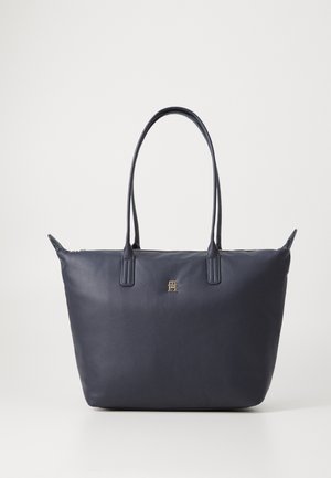 Torbica temno modre barve, izdelana iz gladke usnje, z dvema ročajema, z zadrgo za zapiranje in diskretnim zlatim logotipom spredaj.