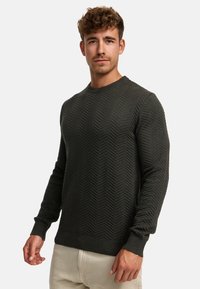Dunkelgrüner, strukturierter Pullover mit Fischgrätenmuster, Rundhalsausschnitt und langen Ärmeln. Gerippte Bündchen und Saum, aus einem weichen Material.