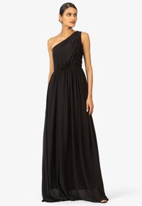 Abito maxi nero a spalla unica realizzato in tessuto leggero, con vita arricciata e gonna fluida per una silhouette elegante.