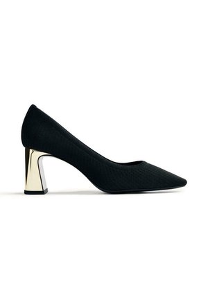 Zapato de tacón de tejido negro con punta afilada y tacón bloque metálico. La parte superior tiene un acabado texturizado que realza su diseño moderno.