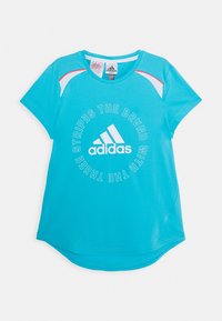 Camisa atlética turquesa de manga corta, con cuello redondo y acentos blancos en contraste. Presenta un texto en negrita y el logo de adidas en el centro.