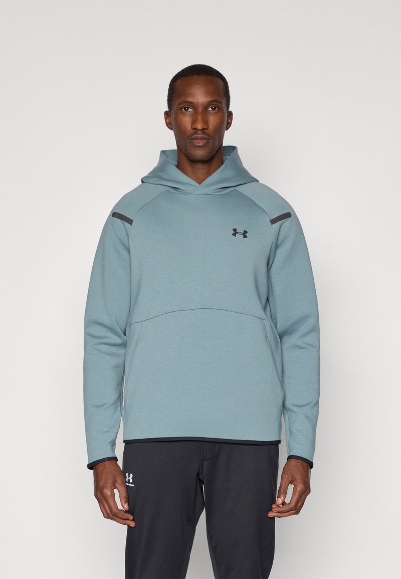 Světle modrá mikina s kapucí s texturovaným povrchem, na ramenou je doplněna černými akcenty a na hrudi se nachází logo Under Armour.