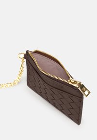 Brown woven leather wallet with a gold zipper, chain attachment, and a pink interior lining. Features a smooth texture and compact design.