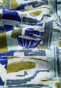 Fabric with abstract pattern, featuring navy, green, and white colors. Textured with visible brush strokes and shapes, resembling watercraft.