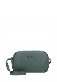 Klein rechthoekig groen leren crossbodytasje met zilveren "HUGO" logo en afneembare strap die vooraan gewonden is.