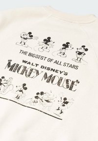 Cremefarvet sweatshirt med sorte trykte illustrationer af Mickey Mouse i forskellige positurer, med tekst der lyder "WALT DISNEY'S MICKEY MOUSE."