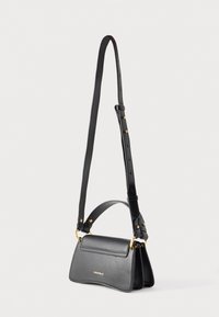 Borsa a tracolla in pelle nera con tracolla regolabile, dettagli dorati, piccolo manico e discreto logo "Coccinelle" sul davanti.