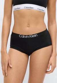 Μαύρο βαμβακερό εσώρουχο hipster με φαρδιά ελαστική ζώνη μέσης που φέρει το λογότυπο Calvin Klein σε λευκό, με λεία υφή και εφαρμοστή σχεδίαση.