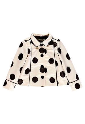 Kremfarvet jakke med lange ærmer med store sorte polkaprikker, sort kantdetalje, rundet krave og fire knapper foran.