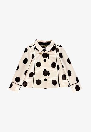 Kremowa kurtka z długim rękawem z dużymi czarnymi groszkami, czarnymi lamówkami, zaokrąglonym kołnierzem i czterema guzikami z przodu.