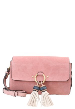 Roze suède crossbodytas met verstelbare riem en gouden ringdetail dat twee witte en blauwe kwastjes aan de voorsluiting houdt.