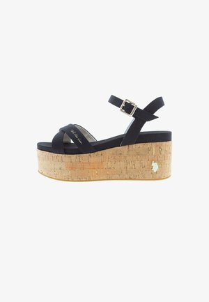 Schwarze Riemchensandale mit Kork-Plattformkeil und verstellbarem Knöchelriemen, mit einem kleinen goldenen Emblem an der Ferse.