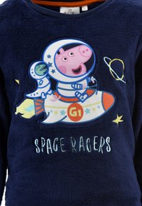 Navy fleece top featuring a colorful "Space Racers" design with characters in astronaut suits, stars, and a rocket graphic.
