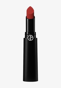 Labial rojo en un estuche negro mate con punta redondeada. Presenta un logo plateado en el lateral. Textura suave, color intenso.