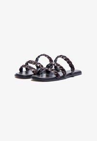 Black leather sandals with braided straps and a flat sole. Features a simple, open design suitable for warm weather.