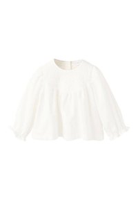 Bela dolgoročna bluza z okroglim izrezom, okrašena s smokom na sprednjem delu in nabranimi rokavi, ki se zaključujejo z elastičnimi manšetami.