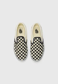 Mustard ja kreemide ruuduline libistatavad jalanõud, millel on kummist tald, ümar varvas ja valged õmblused servadel. Vans logo sisetaldadel.