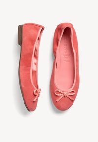 Bailarinas de ante coral con punta redonda, pequeño tacón y lazo decorativo en la parte delantera. Interior forrado con material rosa suave.