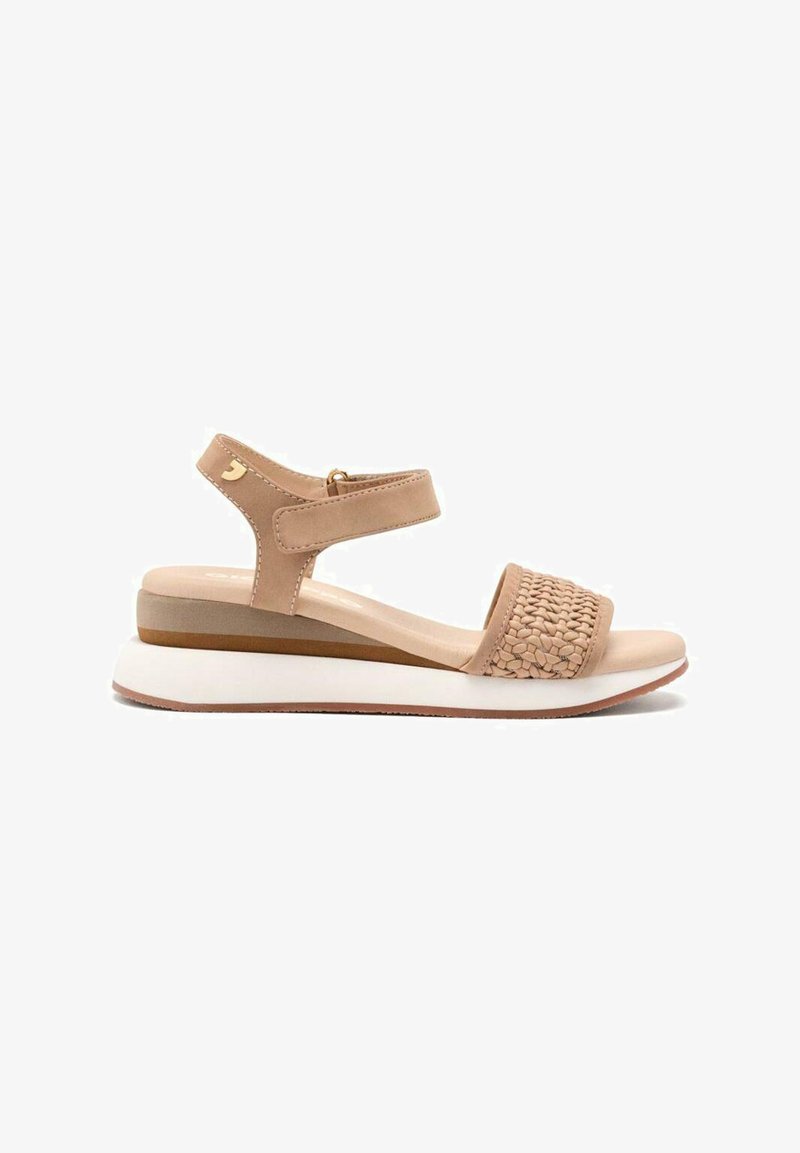 Sandalias beige con una correa frontal trenzada, correa de tobillo ajustable y suela blanca con un diseño en capas en tonos marrones y beiges.