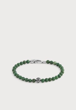 Bracelet vert à perles avec un fermoir rond en argent et une perle centrale décorative en argent gravée du mot GUESS.