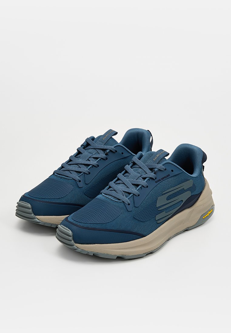 Scarpe sportive blu realizzate in mesh e materiali sintetici. Presentano una punta rotonda, lacci e una intersuola grigia a contrasto con accenti in metallo.