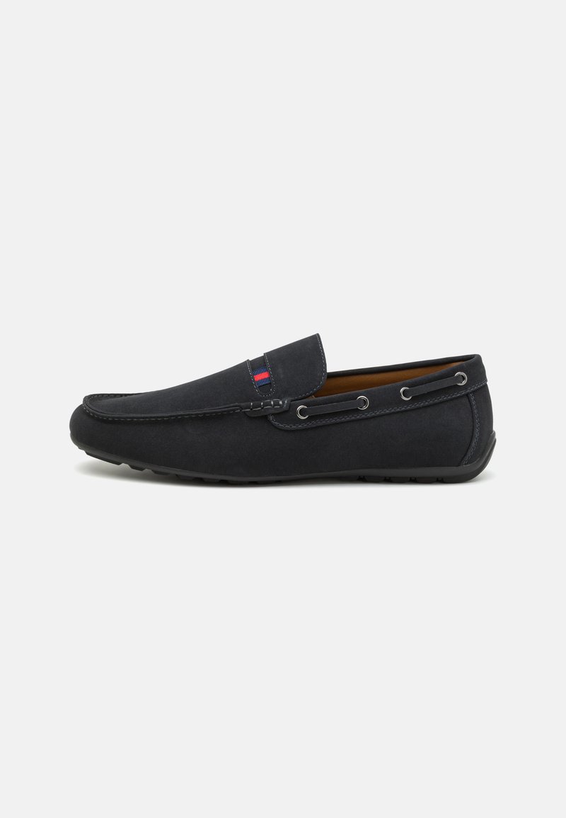 Mocassins en daim bleu marine avec un embout arrondi, design à enfiler, coutures décoratives et œillets en métal sur le côté. Semelles en caoutchouc pour une meilleure adhérence.