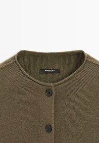 Olivgrüner Strickcardigan mit rundem Ausschnitt und zwei schwarzen Knöpfen, mit dem Etikett Massimo Dutti, hergestellt in China.