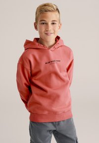 Sudadera de algodón rosa con bolsillo canguro, cordón ajustable y diseño de texto que dice "BLUE RIDGE DENIM" en la parte frontal.