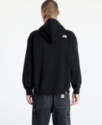 Sudadera negra con capucha y un logo en la parte posterior, con puños y dobladillo acanalados, hecha de material suave, combinada con pantalones cargo oscuros.