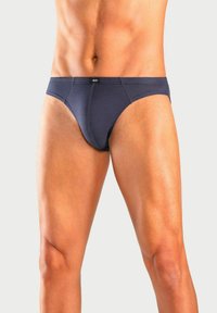 Herren Slips in Marineblau aus glattem Stoff, mit einem mittelhohen Schnitt und einem elastischen Bund mit Logo. Minimale Nähte sorgen für zusätzlichen Komfort.