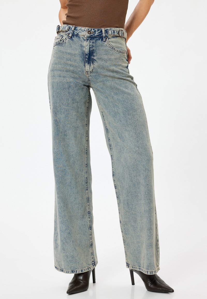 Ljusblå vida jeans med en urtvättad look, med hög midja, fem fickor och stickade detaljer. Tillverkad av denimmaterial.