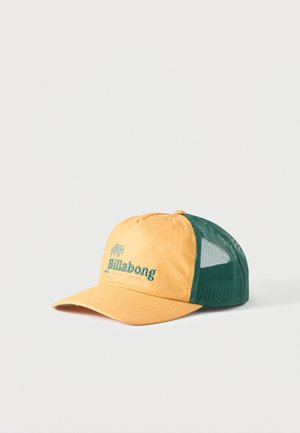 Gorra trucker de malla amarilla y verde con visera curva y logo "Billabong" en color verde azulado con bordado de palmera en el panel frontal.