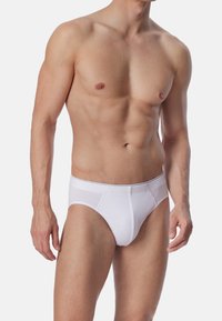 Weißer Baumwollslip mit glatter Textur, passgenauer Form und festem Bund. Verfügt über minimale Nähte und einen klassischen Schnitt.