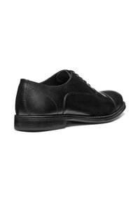 Chaussure de ville en cuir noir avec finition lisse, bout rond et design classique à lacets. Elle présente un petit talon empilé et des coutures discrètes.