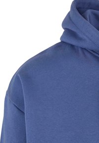 Felpa con cappuccio blu, realizzata in un tessuto morbido e textured. Il design include una vestibilità comoda e un grande cappuccio piegato.