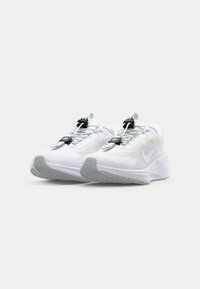 White running shoes with a mesh upper, featuring a curved sole, black laces, and a reflective Nike logo. Light grey outsole with textured pattern.