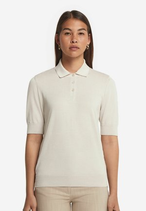 Hellbeige Poloshirt mit kurzen Ärmeln aus einem weichen Strickgewebe, ausgestattet mit einem klassischen Kragen, drei Knöpfen sowie gerippten Bündchen und Saum.