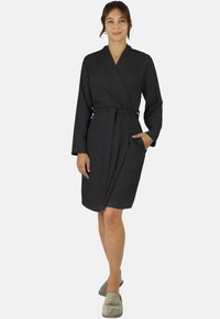 Schwarzer, strukturierten Bademantel mit Wickeldesign, langen Ärmeln, einem Bindegürtel in der Taille und Seitentaschen. Weicher Stoff, knielange Passform.