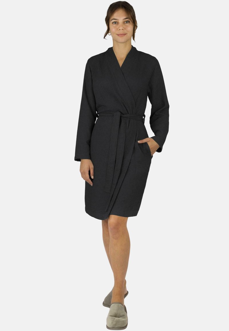Schwarzer, strukturierten Bademantel mit Wickeldesign, langen Ärmeln, einem Bindegürtel in der Taille und Seitentaschen. Weicher Stoff, knielange Passform.