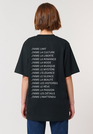 T-shirt in cotone nero con testo bianco sul retro che elenca frasi che iniziano con "J'aime", in una vestibilità comoda con maniche corte.