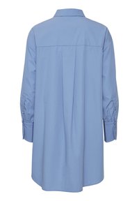 Camicia azzurro chiaro con maniche lunghe, polsini con bottoni, una piega sul retro e colletto. Tessuto liscio e intrecciato con una vestibilità comoda.