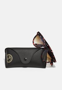 Ray-Ban'i prillid mustade, kilpkonnakujuliste raamidega. Kaasas on tekstuuriga must karp kuldse logo pitseri ja nupuga sulgemisega.