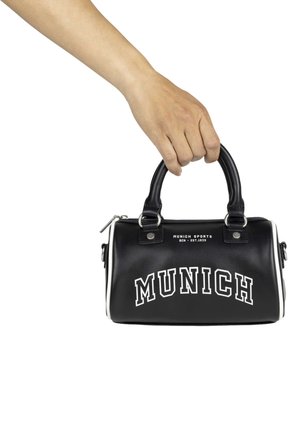 Bolso sintético negro con asas redondeadas, ribetes blancos y el texto prominente en blanco "MUNICH" en la parte frontal. Parte superior con cremallera.