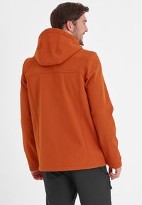 Orange softshell jacket with a hood, featuring a smooth texture, stitched details, and a relaxed fit. Designed for outdoor comfort.